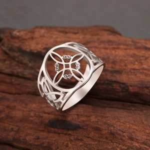 Vue macro de la bague nœud de sorcière argentée sur une surface en bois naturel