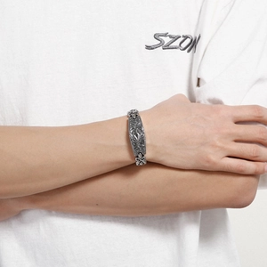 Nahaufnahme eines Vintage-Silberarmbands mit gotischen Gravuren und Fleur-de-Lis-Motiven