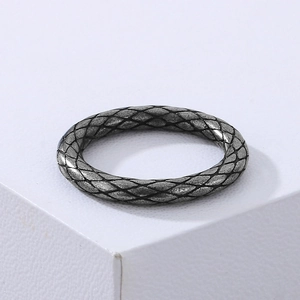 Macro detail of retro stainless steel ring featuring snake scale texture and aged finish