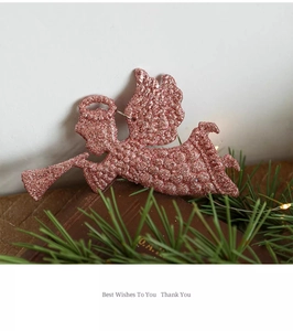 Pink glitter angel ornament with trumpet for Christmas tree decoration on books