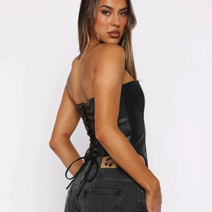 Vue détaillée du laçage sexy au dos d'un haut bustier en cuir noir sans bretelles