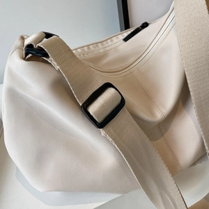 Minimalist beige nylon tote bag with wide adjustable shoulder strap and high-density texture