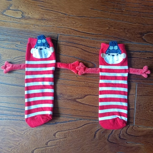 Detail of magnetic hand-holding socks featuring red striped pattern and cute 3D monkey arms