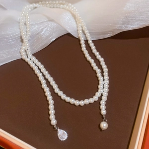 Detail of double-layer pearl necklace with a teardrop crystal pendant and soft texture