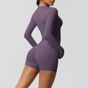 Detail view of deep purple long-sleeved yoga top and shorts set with seamless texture
