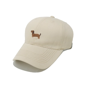 Close-up of cute dachshund puppy embroidery on beige twill cotton baseball cap