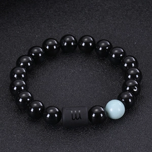 Detail of Scorpio zodiac charm on black onyx and tiger eye beaded stretch bracelet