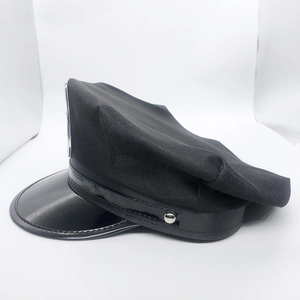 Side close-up of the black uniform hat featuring twill fabric and a shiny patent leather brim