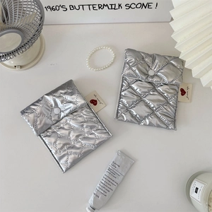 Detail of silver quilted sanitary pad pouches with heart labels and button closure
