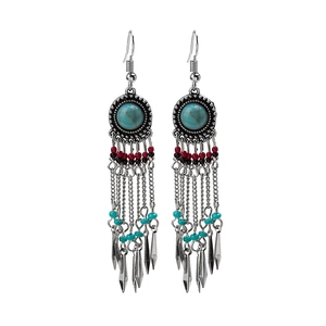 Detail of bohemian earrings with turquoise beads and metallic conical fringe charms