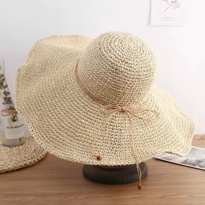 Summer beach wide brim straw hat with decorative bow and wooden beads in beige