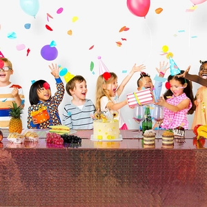 Close-up of shiny reddish-brown laser party tablecloth decorated for birthday celebrations