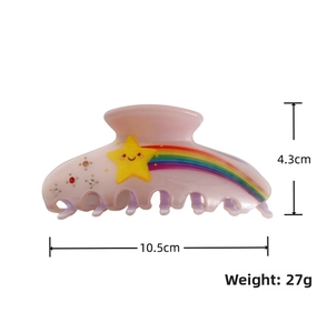 Detail view of pink hair claw clip with rainbow star and rhinestones measuring 10.5cm
