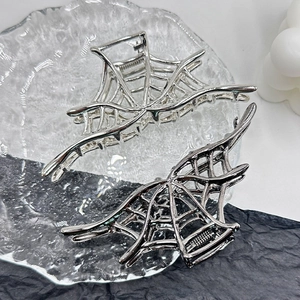 Detail of metal spider web hair claws in silver and black finishes for Halloween
