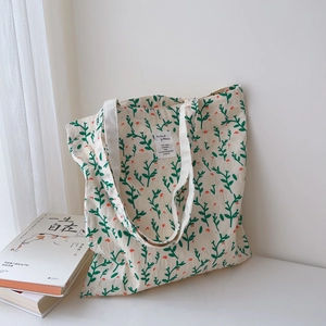 Detail of floral canvas tote bag with green leaves and a central fabric label