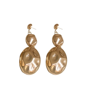 Minimalist gold oval earrings with irregular hammered texture and metallic finish