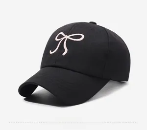 Détail de la broderie nœud rose sur une casquette de baseball noire vue de profil