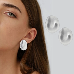 Detailed view of silver irregular oval earrings featuring a brushed metallic texture