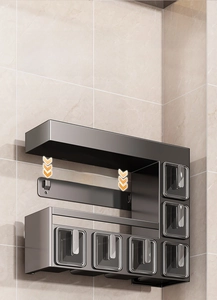Detail of wall-mounted kitchen spice rack with grey metal frame and clear storage drawers