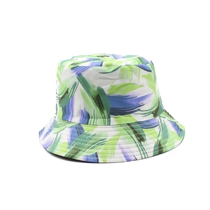 Dettaglio del cappello da sole reversibile con pennellate astratte blu e verdi
