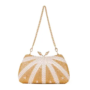Elegant beaded evening bag with white pearls, gold details, and a bird-shaped clasp