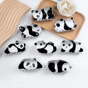 Cute panda hair claws set in black and white acrylic shown on minimalist wood tray