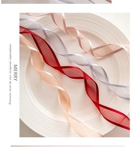 Close-up of translucent champagne, red, and silver organza ribbons for Christmas decor