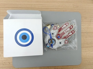 Detailed Hamsa Hand metal ornament with blue evil eye beads and small hanging bell charms