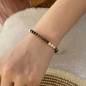 Detailed shot of beaded tiger eye bracelet with gold spacers on a cozy wool surface