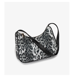 Close-up of gray leopard print texture and black leather trim on a stylish shoulder bag