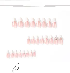 Detailed view of pink almond press-on nails with white French tips and silver heart charms