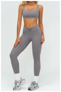 Detail of grey yoga set featuring U-neck sports bra and high-waisted leggings with cross-waist