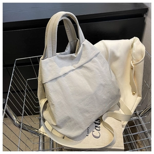 Detailed close-up of cream nylon cloud tote bag in a metal basket for daily styling