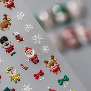 Macro shot of 3D embossed Christmas nail art stickers featuring Santa and nutcrackers