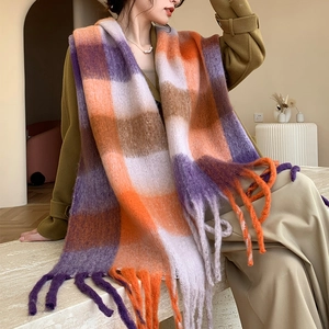 Détail d'une écharpe à carreaux orange et violet avec des franges portées par un mannequin