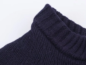 Close-up of high-quality navy blue knit fabric showing ribbed neckline detail and texture