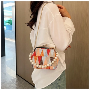 Chic geometric patchwork shell bag with pearl handle and golden chain strap detail