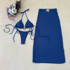 Flat lay of blue three-piece bikini set with mesh skirt and gold starfish buckles