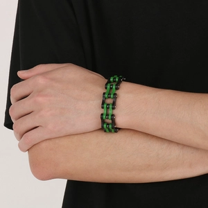 Primo piano del bracciale a catena di bicicletta nero e verde al polso in stile rock