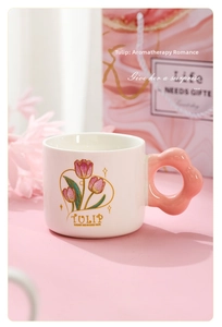 Close-up of ceramic tulip mug featuring a pink flower-shaped handle and elegant gift bag