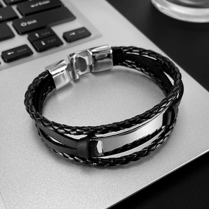 Men's braided leather bracelet with stainless steel magnetic clasp on a silver laptop