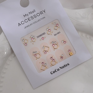 Detailed view of pink crystal rhinestones and gold geometric nail charms on MJ-063 card