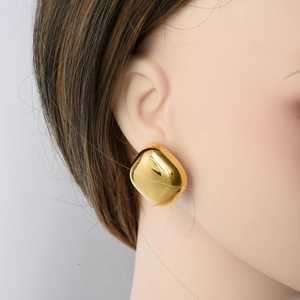 Polished gold square dome earrings in 304 stainless steel shown on a model