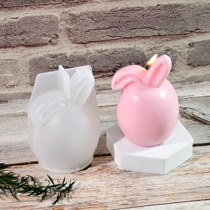 Macro view of pink bunny candle with soft silicone mold on vintage brick background