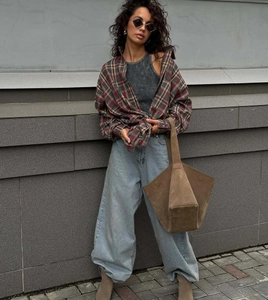 Plaid long-sleeve shirt styled with a grey tank top and light blue high-waist denim jeans