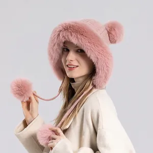 Rosafarbene Winter-Strickmütze für Damen mit Ohrenklappen und großen Plüschbommeln