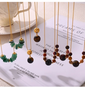 Close-up of beaded necklaces with tiger eye, agate, and green stones on golden chains