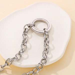Detailed view of silver link chain necklace with double ring pendant and pavé rhinestones