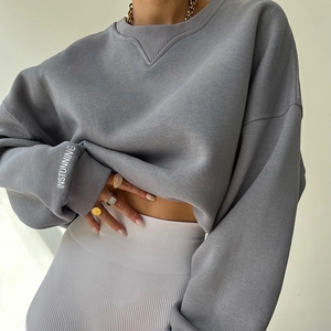 Detail of grey crewneck sweatshirt sleeve with INSTUNNING print and ribbed white leggings