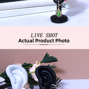 Detailed shot of emerald earrings and crystal ear cuffs on silicone model stands